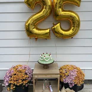 a table with a cake and balloons