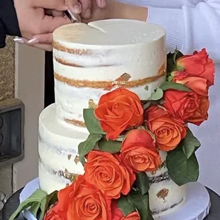 a man and woman cutting a wedding cake