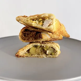 Empanadas (top to bottom): Chicken &amp; Corn, Beef w/ olives, raisins, boiled egg, and Potato Samosa | $5-$6 each