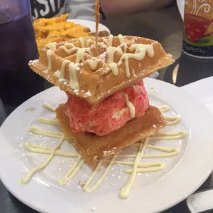 Vanilla ice cream covered in Strawberry shortcake crumbs sandwiched between warm  Belgian waffles drizzled with Vanilla cream!