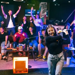 a woman swinging a golf club bat