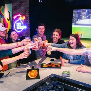 a group of people toasting at a bar