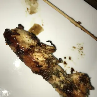 a chicken skewer on a white plate