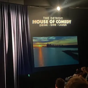 a man standing on stage in front of a crowd