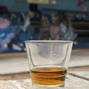 a glass of whiskey on a wooden table