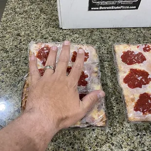 A hand that makes the pizza a pathetic size for cost.