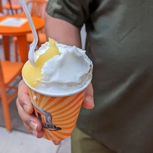 a man holding a cup of ice cream