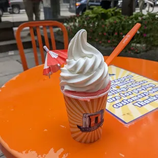 a cup of ice cream on an orange table