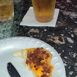 a slice of pizza and a glass of beer