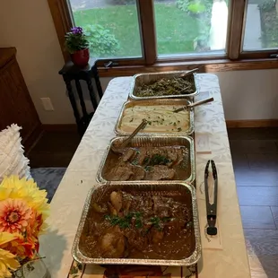 Beef brisket with gravy, sliced roasted pork with gravy, mashed potatoes and green beans with bacon.