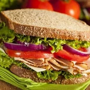 a turkey sandwich with lettuce and tomatoes