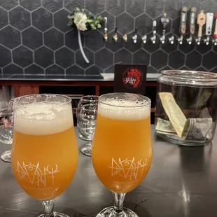 two glasses of beer on a bar