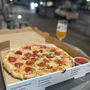a box of pizza and a glass of beer
