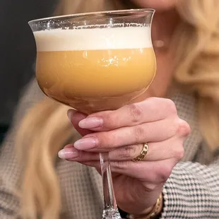 The Blood Orange Flip is made with Blood Orange Gin, Orange Blossom, Tiki Bitters, Whole Egg, and Soda.