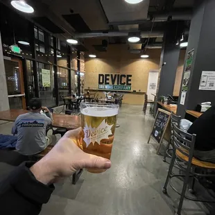 a person holding a pint of beer
