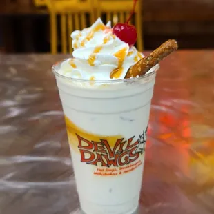 a milkshake with whipped cream and a pretzel