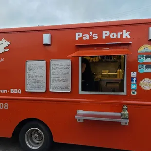 a red food truck parked in a parking lot