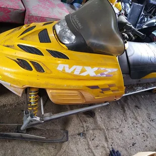 a yellow snowmobile parked in a garage