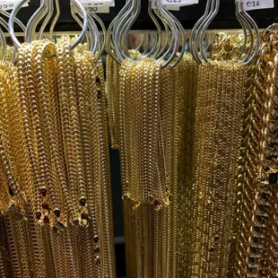 a display of gold chains and bracelets