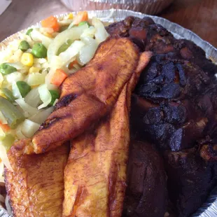 Stewed chicken small plate served with sweet plantain, beans and rice, mixed vegetables