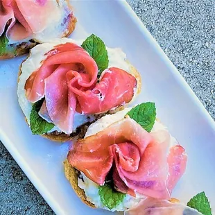 a platter of sandwiches with prosciutto and prosciutto