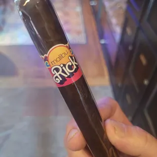 a hand holding a cigar