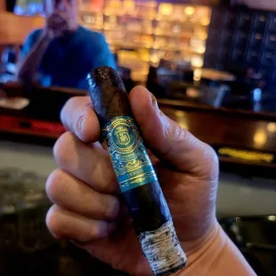 a hand holding a cigar