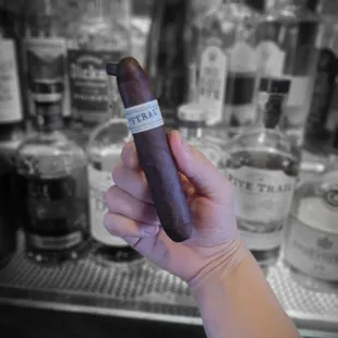 a hand holding a cigar