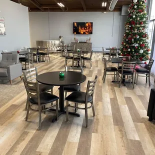 a dining room with a christmas tree in the background