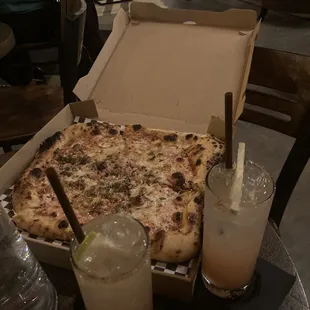 a pizza and drinks on a table