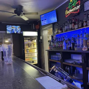 a bar with a bar counter and televisions