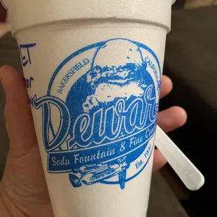 a hand holding a cup of ice cream