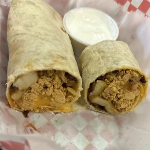 A chorizo, egg and potato burrito with sour cream on the side.