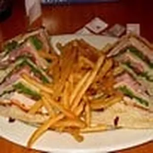 Club Sandwich made with roast beef, bacon, turkey and ham with a side of fries.