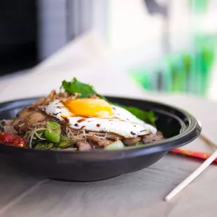 a bowl of food with chopsticks