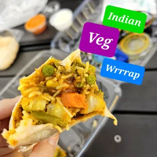 a hand holding a burrito