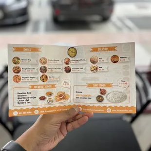 a hand holding a menu for a restaurant