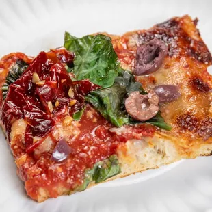 a slice of pizza on a paper plate