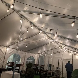 a man standing under a tent