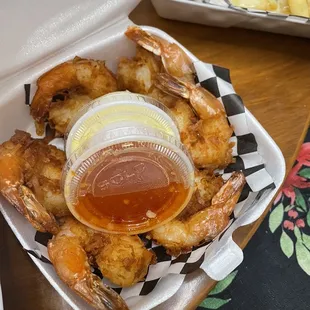 a tray of shrimp with a side of macaroni and cheese