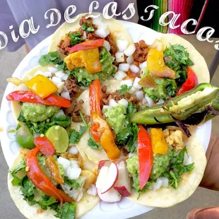 A large plate of our Delicious Tacos with all the fixings including fajita style veggies