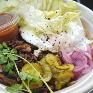 Brisket Bowl. Brown rice, fried runny egg, pickled cucumbers and onions, lettuce, bbq sauce. Brisket was crispy and tender
