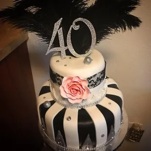 a black and white cake with a pink rose