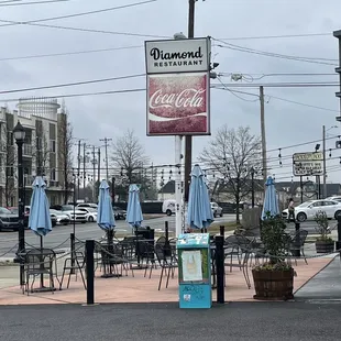 tables and umbrellas on a street corner