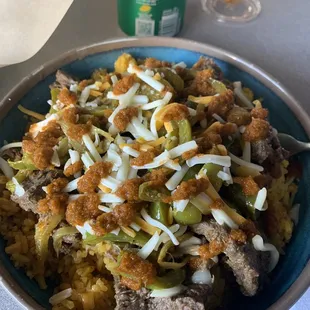 Chicago Bowl with PR rice, steak, onions, green peppers, cheese and a mild hot sauce on top.