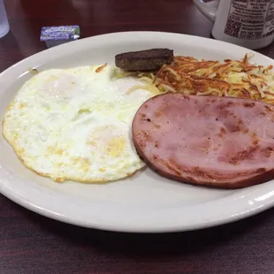 Three eggs over medium hashbrowns and ham