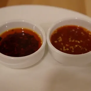 Chili oil on the left and hot sauce on the right.