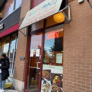 a woman standing in front of a restaurant