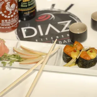 a plate of sushi and chopsticks