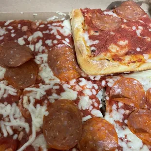 Pepperoni pizza that was stacked on top of each other in the small box